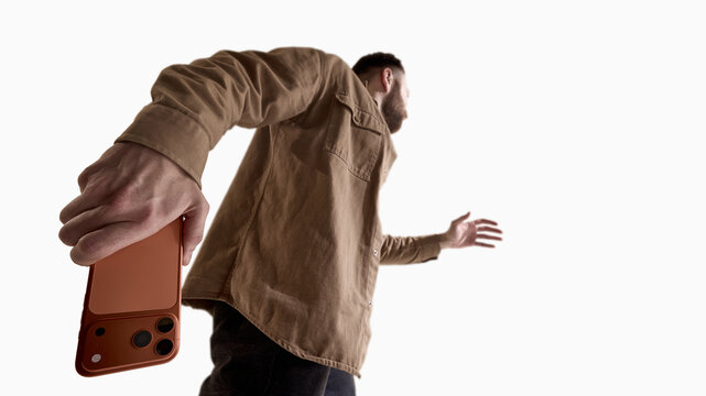 Man holding smartphone behind back from low perspective isolated on white. Concept of hidden message, secret communication, online privacy, digital security and confidential mobile interaction.
