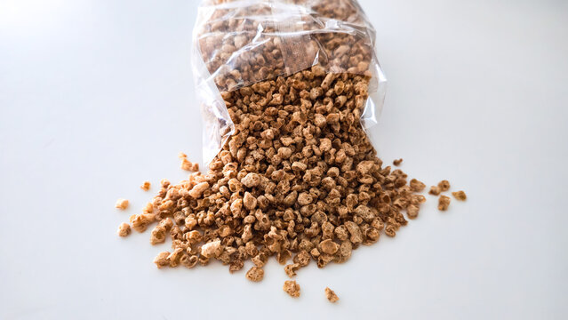 Raw Plant-Based Vegan Meat Substitute (Pea/Soy Protein) Spilled on White Background