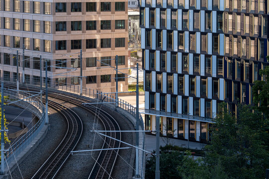 Railway tracks guide a train through urban transport commute infrastructure near office towers in Stockholm Sweden connecting city routes