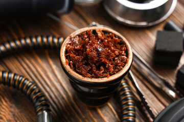 Parts of hookah with tobacco on wooden background