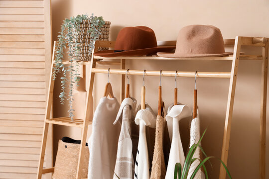 Rack with warm clothes and hats in dressing room
