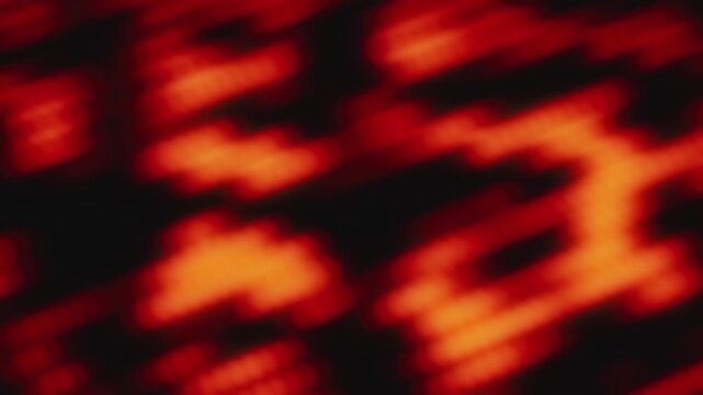 Seamless loop of futuristic abstract 3D animation. Blurred diagonal lines in red and orange colors moving on black background. Soft flowing motion graphic with bokeh effect for smooth textures.