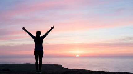 Fototapeta premium Silhouette of a woman with raised arms standing on a cliff overlooking the ocean at sunset. Freedom, success and mindfulness concept.