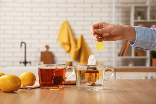 Brewing of black tea in glass cup on table in kitchen
