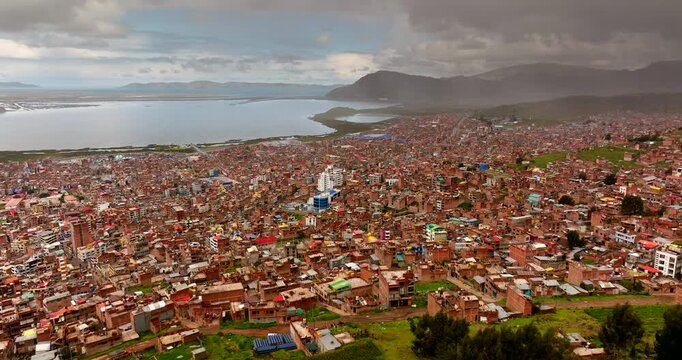 Congested and populous Puno city on Lake Titicaca shoreline, high aerial