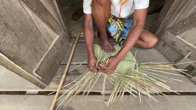 Malagasy woman weaving a basket using the traditional method in Ambinanitelo, Madagascar.