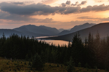 Obraz premium Sunset View Over Pine Forest and Mountain Valley with Lake