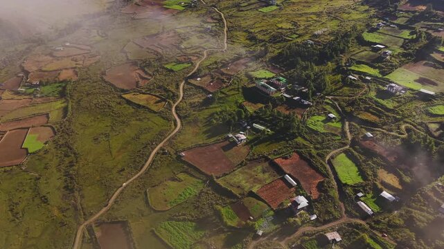 Aerial view of Phobjikha Valley with lush green fields, scattered houses, and winding roads creating a beautiful contrast, Nubding, Bhutan.
