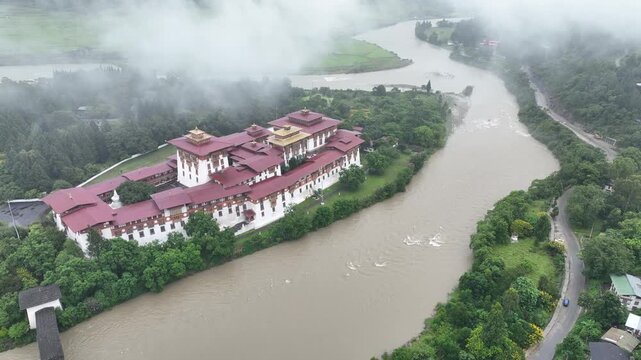 Aerial view of Punakha Dzong is surrounded by the confluence of two rivers, and lush greenery, creating a serene landscape, Punakha, Punakha, Bhutan.
