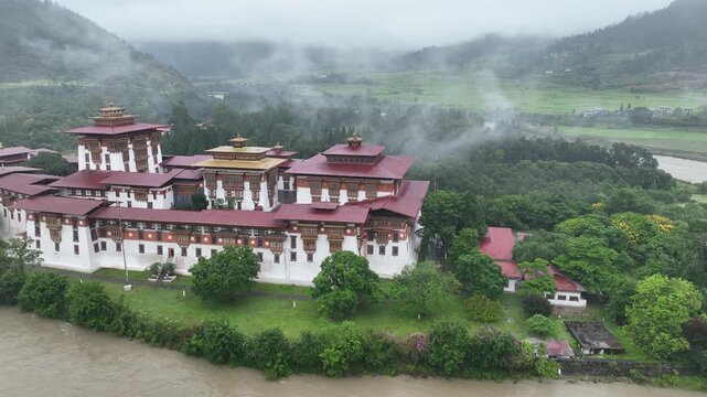 Aerial view of the majestic Punakha Dzong, a fortress monastery, sits at the confluence of rivers amid misty mountains, Punakha, Punakha, Bhutan.