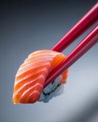 red chopsticks picking up salmon sushi