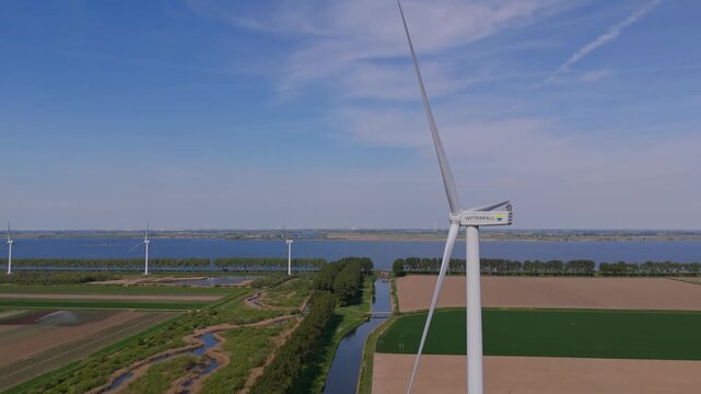 Middelharnis, Netherlands - 28 april 2025: Aerial view of Vattenfall wind turbines, part of Energiepark Haringvliet Zuid, standing tall amidst a patchwork of green and brown fields