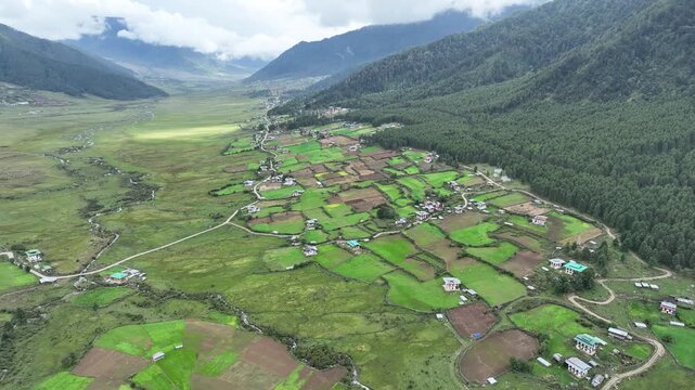 Aerial view of the verdant Phobjikha Valley, a U-shaped glacial valley, showcasing a unique landscape with vibrant green fields, Phobjikha Valley, Wangdue Phodrang, Bhutan.