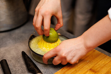 Hands Pressing a Fresh Lime on a Manual Plastic Juicer