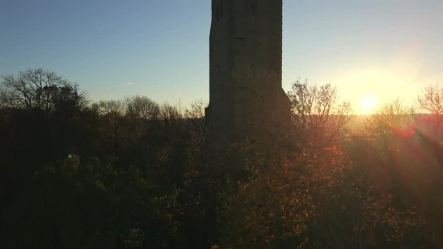 Stirling, United Kingdom - 06 February 2026: Aerial view of the Wallace Monument bathed in the warm glow of the setting sun, casting long shadows across the landscape.