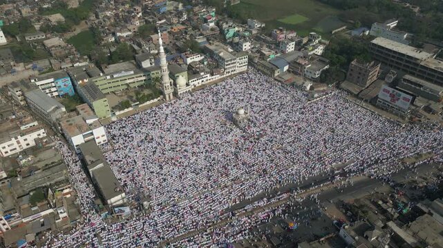 Aerial view of a vast congregation of people gathered in a large open area near a mosque, Malda, West Bengal, India.