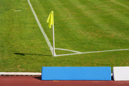 a soccer ball on the green grass on the line on corner in soccer stadium.  corner kick.
