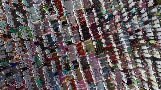 Aerial view of people praying on colorful rugs, a vibrant display of faith and unity, creating a mesmerizing mosaic of devotion, Malda, West Bengal, India.