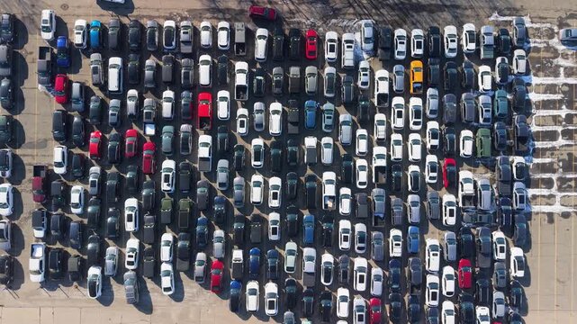 Aerial view of a bustling parking lot filled with cars of various colors, creating a vibrant mosaic against the asphalt, Framingham, Massachusetts, United States.