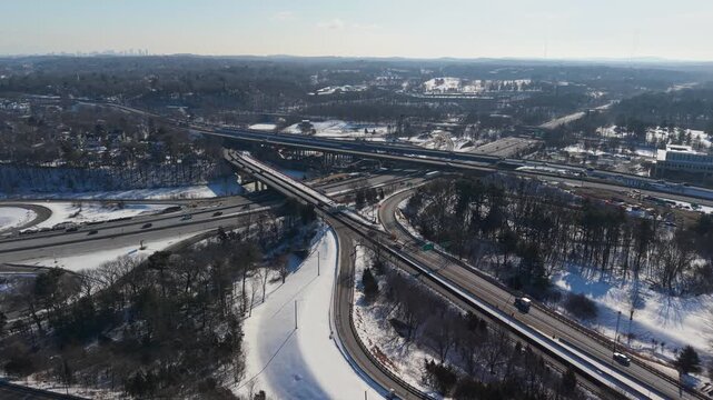 Aerial view of Interstate 95 and surrounding snow-covered landscape, creating a stark contrast with the dark trees, Salisbury, Massachusetts, United States.