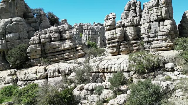 Aerial view of the rugged El Torcal de Antequera, where weathered limestone formations create a dramatic landscape under a clear sky, El Torcal de Antequera, Andalucia, Spain.