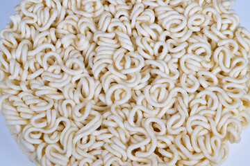 Abstract instant noodles pattern fills frame with looping curls and rhythmic repetition, sculptural texture and pale tones create decorative food art and design motif