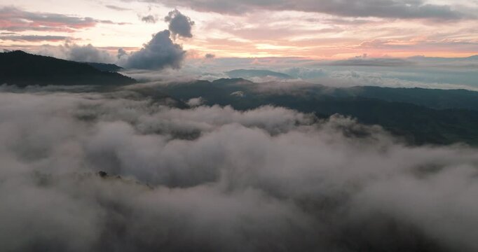 Aerial view of the serene landscape with mountains piercing through the clouds, bathed in the soft glow of the morning light, Nevado del Ruiz, Caldas, Colombia.