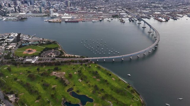 Aerial view of the Coronado Bridge stretching across the bay, connecting the city skyline to the lush green landscape, Coronado, California, United States.