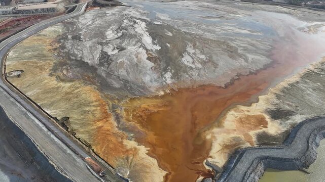 Aerial view of the contrasting whites, grays, and earth tones of the tailings blending into the surrounding landscape, Minas de Riotinto, Andalusia, Spain.