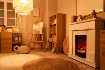 Naklejka premium Interior of living room with fireplace, shelf unit and glowing lamp in evening