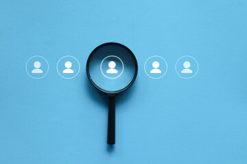 Fototapeta premium close up top view on magnify glass with candidate man icon for hire and recruit new employee to team and company for human resource management and business concept