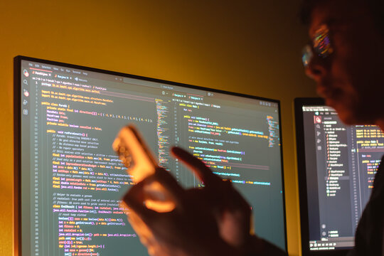 Programmers are writing computer code to develop applications or websites using JavaScript and C++ programming languages, and testing them to ensure the system works efficiently on their smartphones.