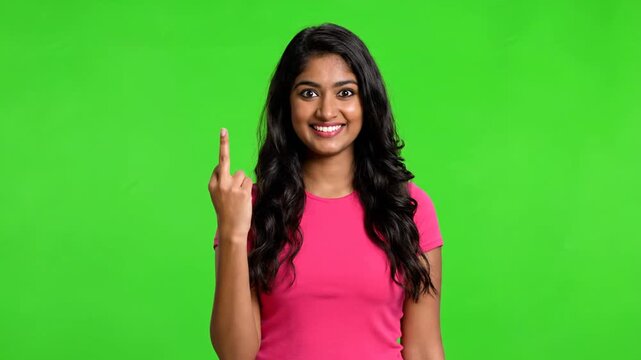 Young woman gesturing with middle finger against a green background