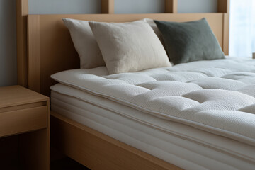 Fototapeta premium Comfortable bed with plush mattress and pillows in a modern bedroom setting