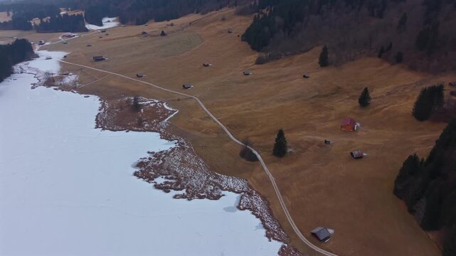 Drone video of snowy Geroldsee near Mittenwald and Kruen. Known as Wagenbruchsee, this scenic spot in Upper Bavaria is a world-famous location for alpine winter tourism.