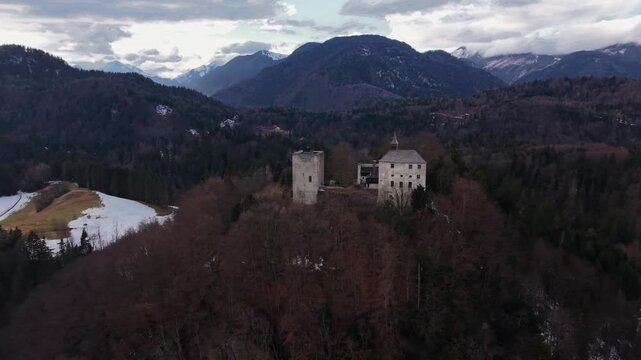 Drone panorama of Burg Thierberg, Tyrol, Austria. Snow covered medieval ruins located between Kiefersfelden and Kufstein. Views of lpine peaks. Ruine Thierberg bei Kufstein in Tirol, Oesterreich.