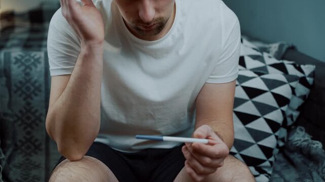Shocked man looking at a pregnancy test with terror in his eyes. Depicting the silent struggle of male infertility and the heartbreak of unsuccessful family planning. Reproductive uncertainty.