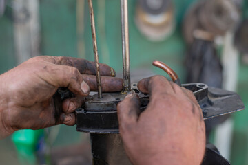 close up hands master auto mechanic repair transmission of outboard marine engine. The mechanic's...