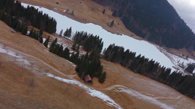 Drone footage of the frozen Wagenbruchsee lake in Kruen. Snowy Geroldsee is a highlight of Bavarian tourism. Panoramic winter view of the Karwendel and Estergebirge peaks.