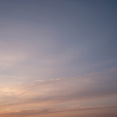 Serene Twilight Sky with Soft Pastel Clouds and Faint Stars Above Horizon at Dusk for Background or Wallpaper Use
