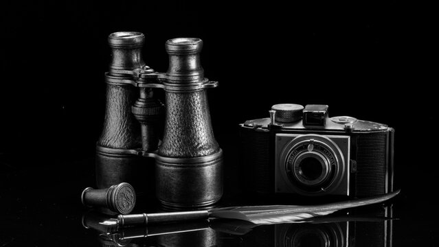 Natura morta con oggetti dell'esploratore. Macchina fotografica, binocolo e penna d'epoca.