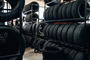 Selbstklebende Fototapeten Altes Krankenhaus Beelitz Stacked black rubber tires on metal racks inside a tire shop with bright lighting and spacious layout, showcasing organized inventory for automotive needs  © standret