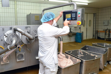 Production of sausages on a conveyor belt in a large meat processing plant - Industrial food processing - Workers in work clothes