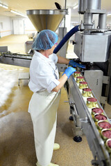 Production of sausages on a conveyor belt in a large meat processing plant - Industrial food...