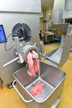 Production of sausages on a conveyor belt in a large meat processing plant - Industrial food processing - Workers in work clothes