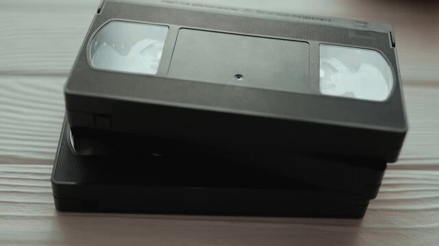 Stack of vintage VHS video cassettes with blank labels. Old analog media technology from 80s and 90s.