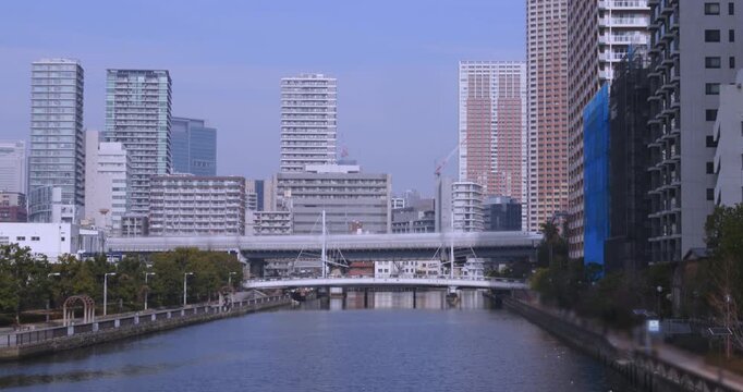 東京湾岸エリアの運河をまたぐ高架橋と高層ビル群の都市景観