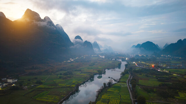 Misty karst peaks and rural scenery at dawn