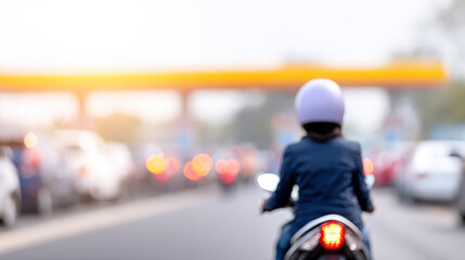 Motorcycle rider in helmet on busy road with blurred cars and oil price impact on traffic flow in evening light