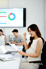 Fototapeta premium Celebrating professional success, a joyful business woman holding document containing exciting news or an approved document, receiving important mail at her modern office desk